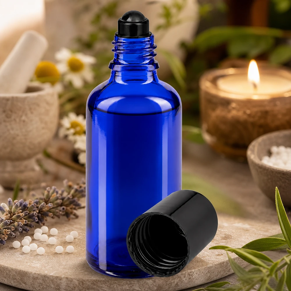 50 ml:n roll-on-pullo, valmistettu UV-suojatusta koboltinsinisestä lasista, jossa on musta pallomainen annostelija, avattuna