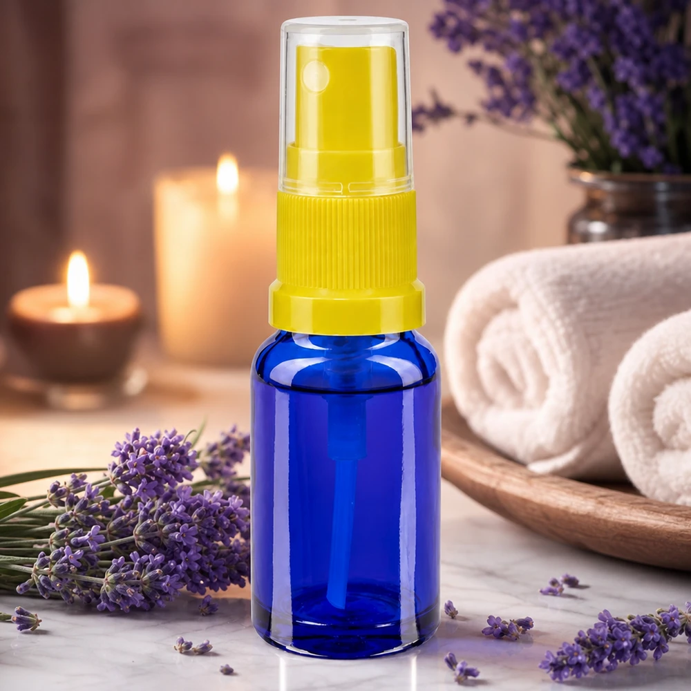 Aromaterapiatarvikkeet: sininen 30 ml:n suihkepullo, jossa on keltainen suihkukärki, laventelikukkien vieressä