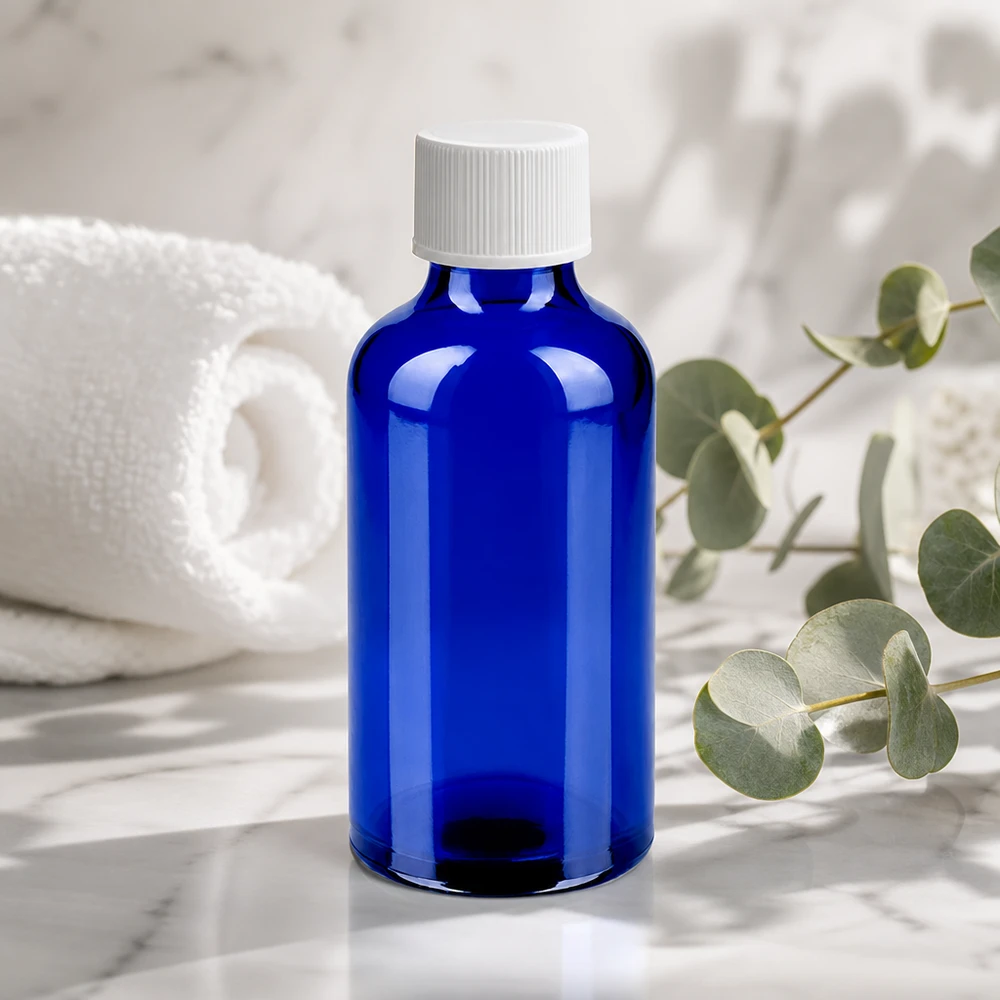 Kompakti 50ml apteekkipullo sinisestä lasista, jossa on UV-suoja ja valkoinen korkki.