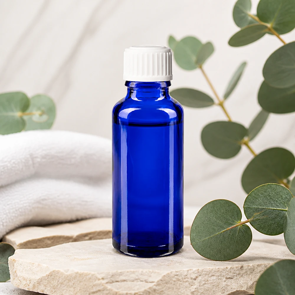 Apteekkipullo sininen 30ml ruuvikorkki valkoinen standardi Koboltinsininen 30 ml:n apteekkipullo, jossa on valkoinen tippakorkki, luonnonkivipohjalla ja eukalyptuksen tuoksulla