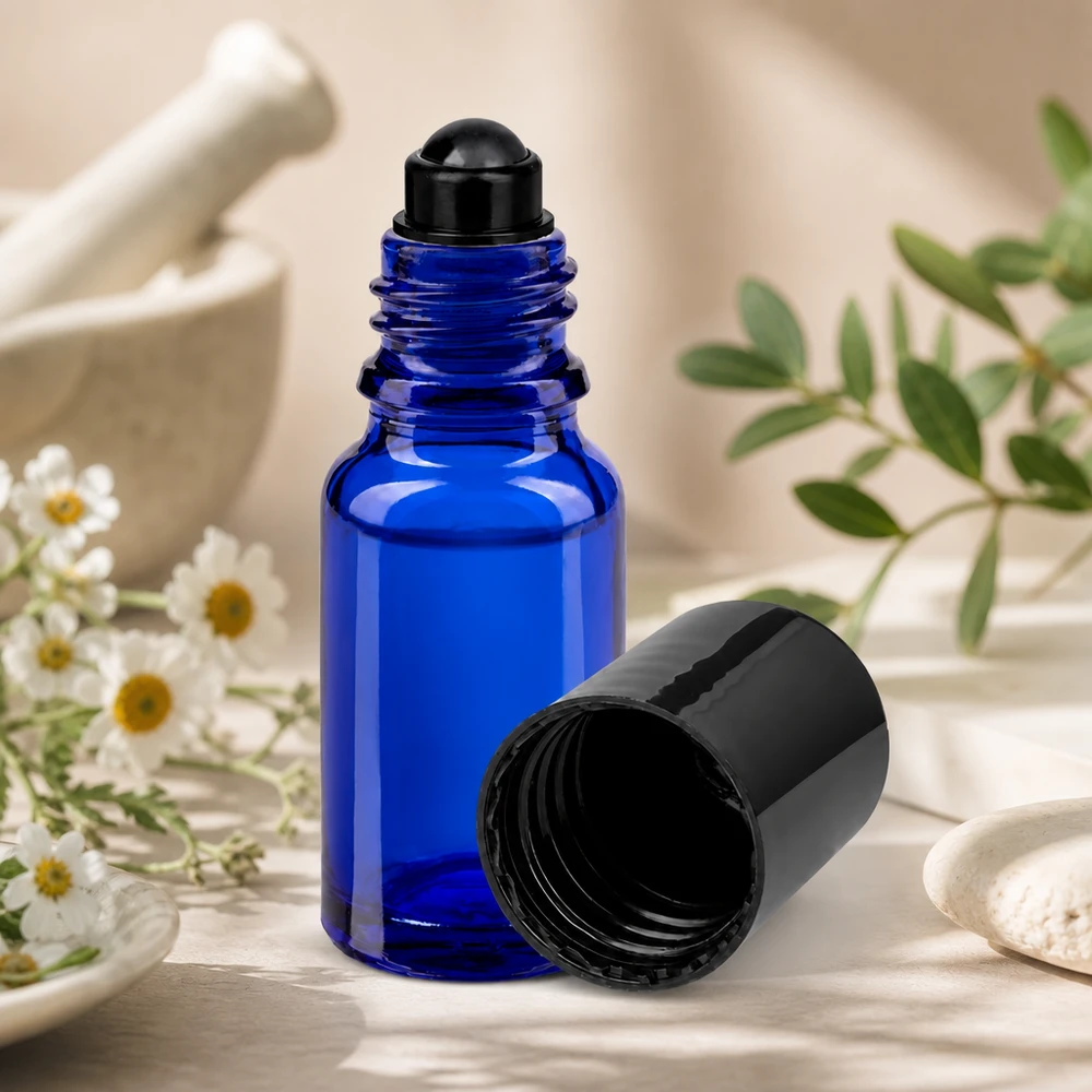 Sininen 10 ml:n STD-roll-on-pullo, jossa on musta korkki, morttelissa olevien yrttien ja kamomillankukkien vieressä