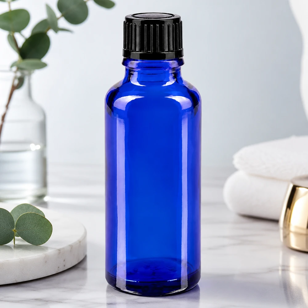 Apteekkipullo sininen 30ml ruuvikorkki musta standardi Koboltinsininen 30 ml:n lasipullo, jossa on musta kierrekorkki, valkoisella marmoripinnalla