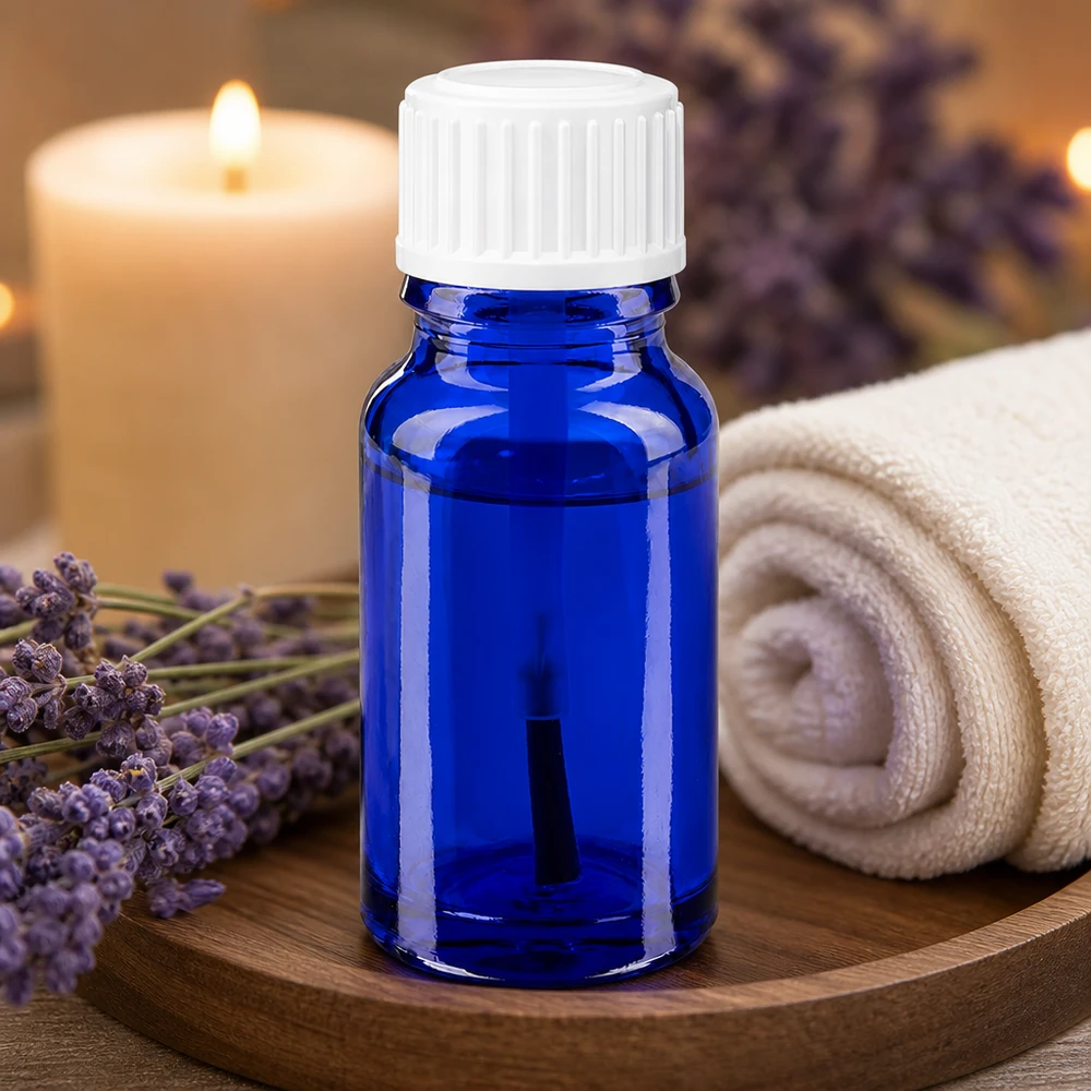 Apteekkipullo sininen 10ml ruuvikorkki valkoinen sivellin Aromaterapiapullo, 10 ml, sininen apteekkilasi, jossa on valkoinen sivellinkärki, laventelikukkien vieressä