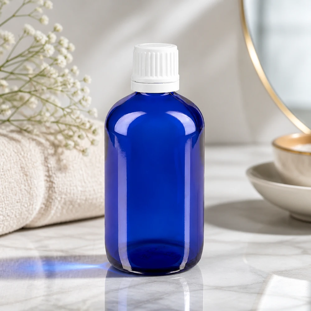 Apteekkipullo sininen 100ml ruuvikorkki valkoinen peukaloinninesto sulkeminen Sininen 100 ml:n lasipullo, jossa on valkoinen OV-korkki, marmorilla pyyhkeen ja kuivakukkien vieressä