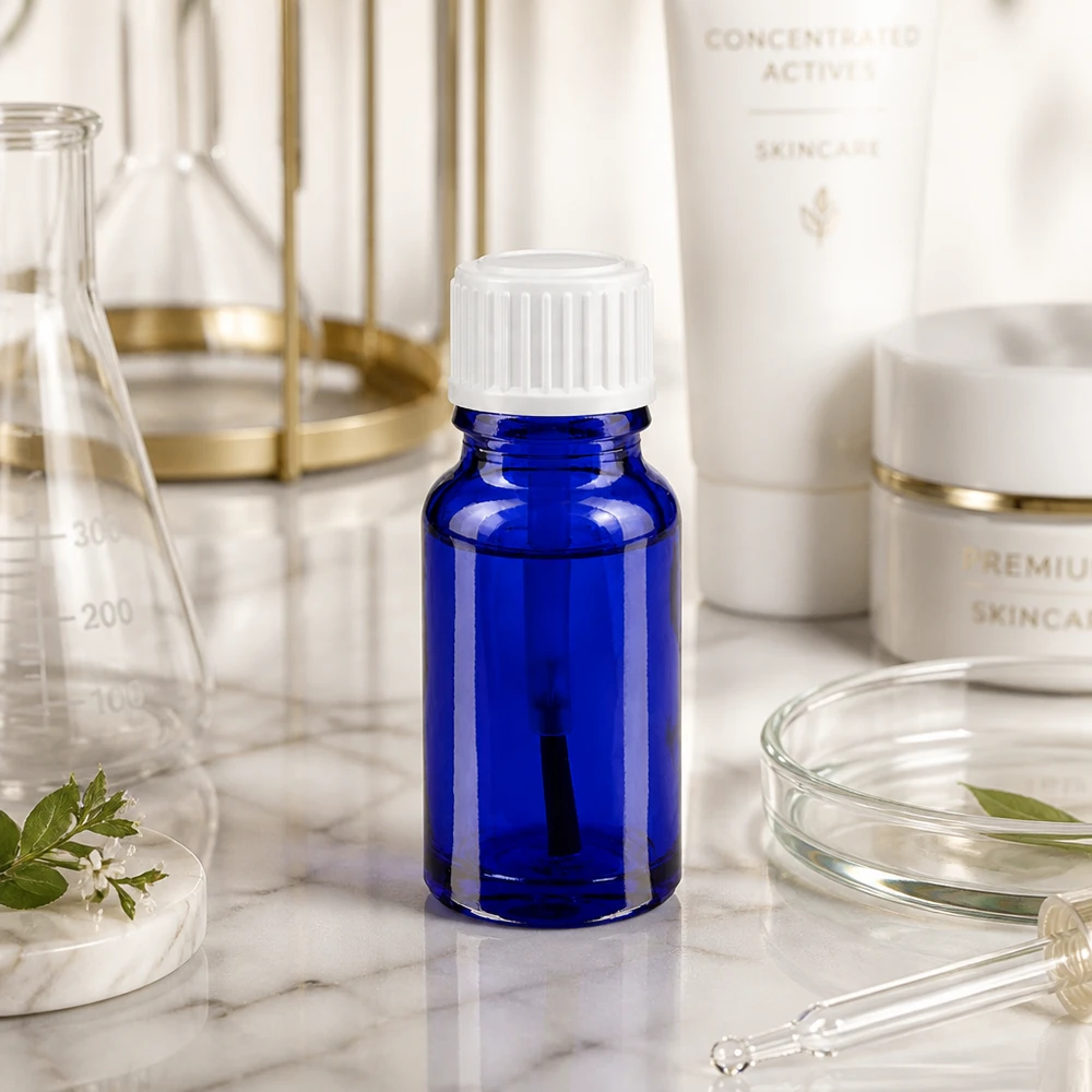 Apteekkipullo sininen 10ml ruuvikorkki valkoinen sivellin Pieni sininen lasipullo (10 ml), jossa on valkoinen kierrekorkki, marmorilevyllä laboratoriotarvikkeiden joukossa