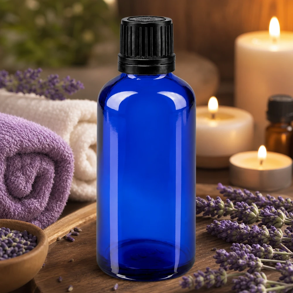 Apteekkipullo sininen 50ml ruuvikorkki musta valurengas peukaloinnin estävä sulkeminen Sininen 50 ml:n lasipullo, jossa on musta tippakorkki, laventelikukkien ja kynttilöiden välissä