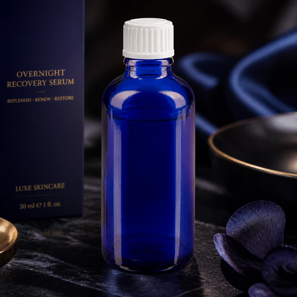 ApoGlas-materiaalista valmistettu sylinterimäinen, koboltinsininen 50 ml:n tiputuspullo, jossa on valkoinen kierrekorkki seerumeille