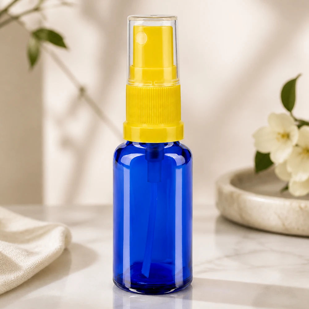Kompakti apteekkisuihkepullo, 20 ml, sinistä lasia, keltaisella pumppupäällä ja läpinäkyvällä korkilla