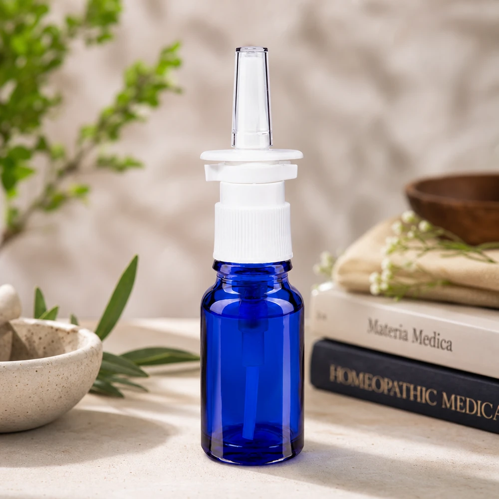 Koboltinsininen 10 ml:n lääkepullo, jossa on ergonominen, valkoisesta muovista valmistettu nenäsumutepumppu