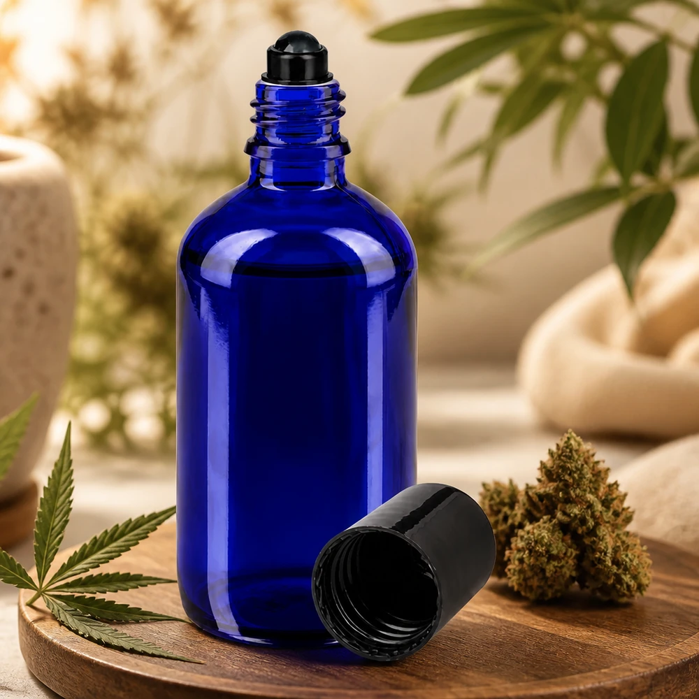 Sininen 100 ml:n roll-on-pullo apteekkilasista kannabiksen kukinnan ja hamppulehden vieressä puulevyllä