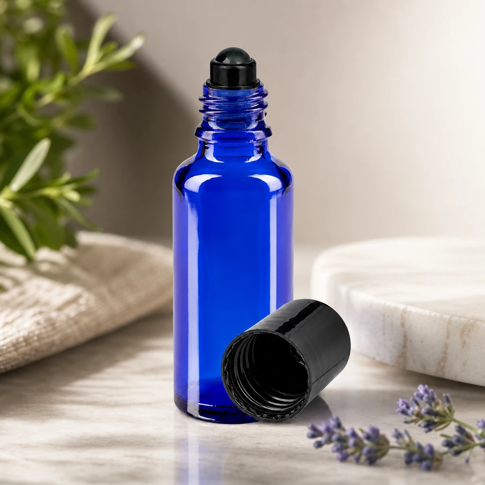 Koboltinsininen 30 ml:n roll-on-lasipullo, jossa on musta korkki, laventelin ja rosmariinipuisen vieressä