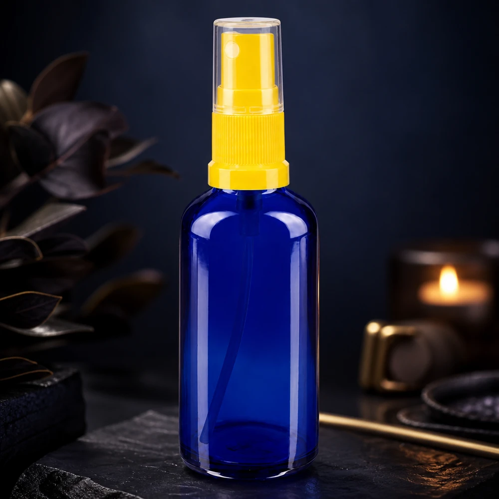 Apteekkipullo sininen 50ml suihkepullon korkki keltainen 50 ml:n sininen lasinen apteekkisuihkupullo, jossa on keltainen sumutin, tummaa taustaa vasten