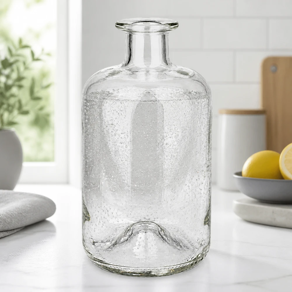 500ml Glasflasche "Luna" ohne Verschluss UNiTWIST Apteekkipullo Luna 500ml, jossa on kuplatekstiili valkoisella keittiön työtasolla sitruunoiden ja kasvien vieressä.
