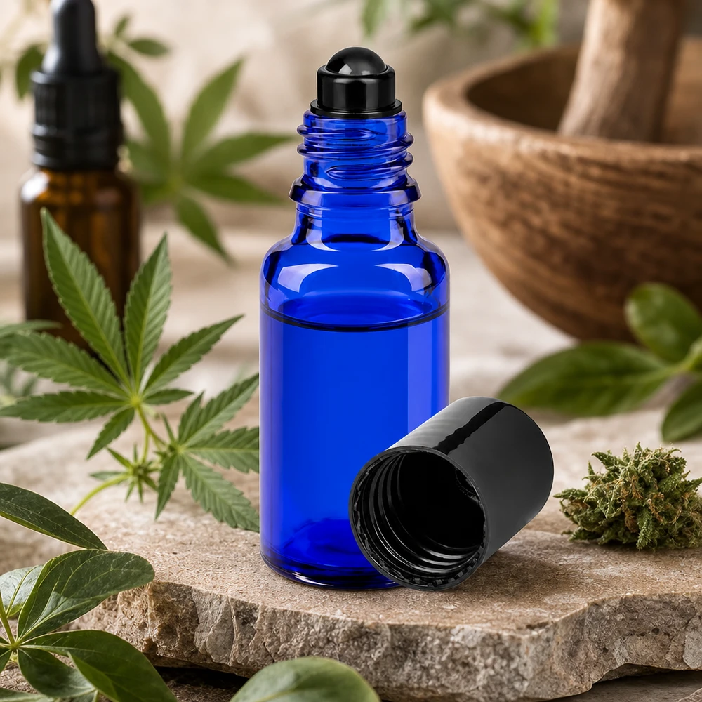 Pieni 20 ml:n roll-on-pullo sinisestä apteekkilasista kannabiskasvin ja morttelin vieressä