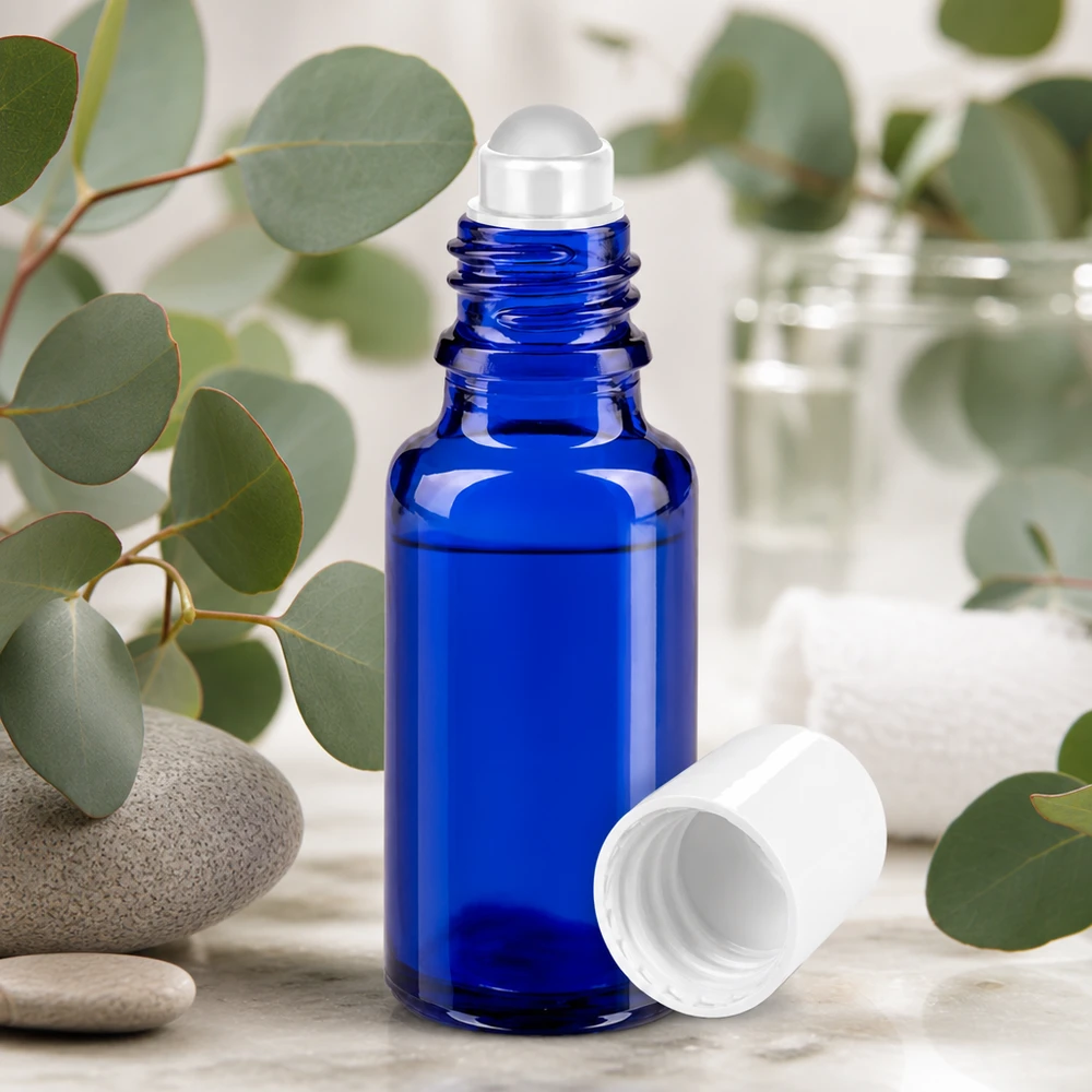 Apteekkipullo sininen 20ml roll-on korkki valkoinen Sininen 20 ml:n roll-on-pullo apteekkilasista, jossa on eukalyptusoksia ja luonnonkiviä