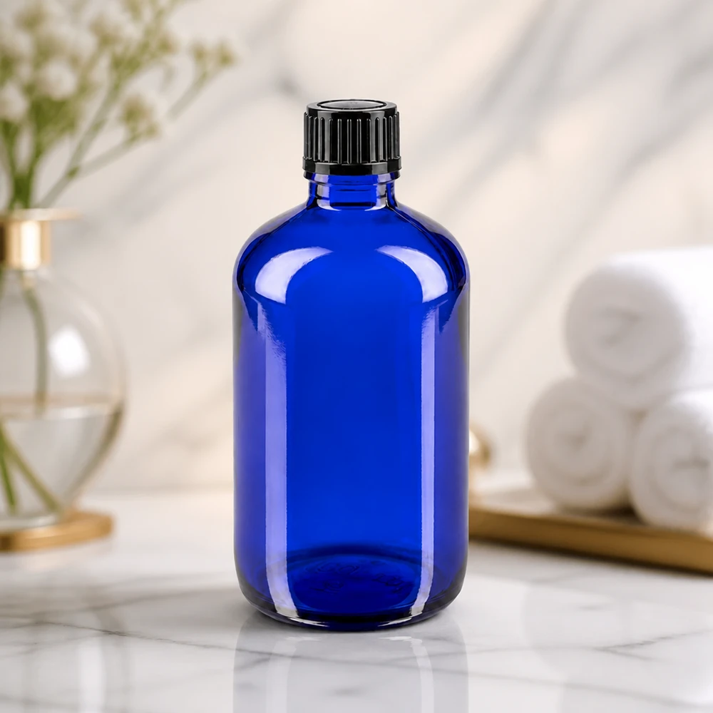 Apteekkipullo sininen 100ml ruuvikorkki musta standardi Sylinterimäinen sininen lasipullo, 100 ml, jossa on uurrettu musta kierrekorkki marmoripinnalla