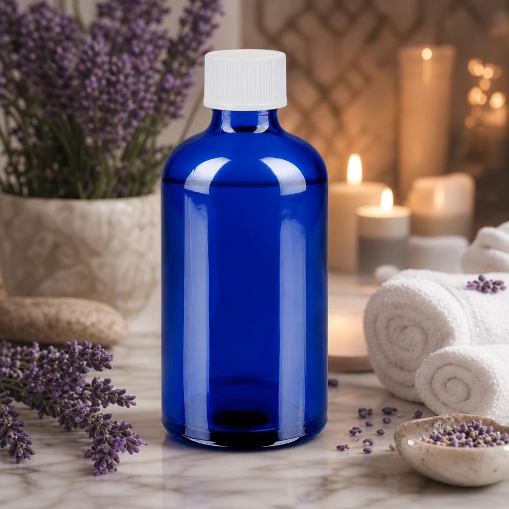 Tyylikäs sininen lasipullo 100ml valkoisella korkilla aromaterapia- ja wellness-sovelluksiin.