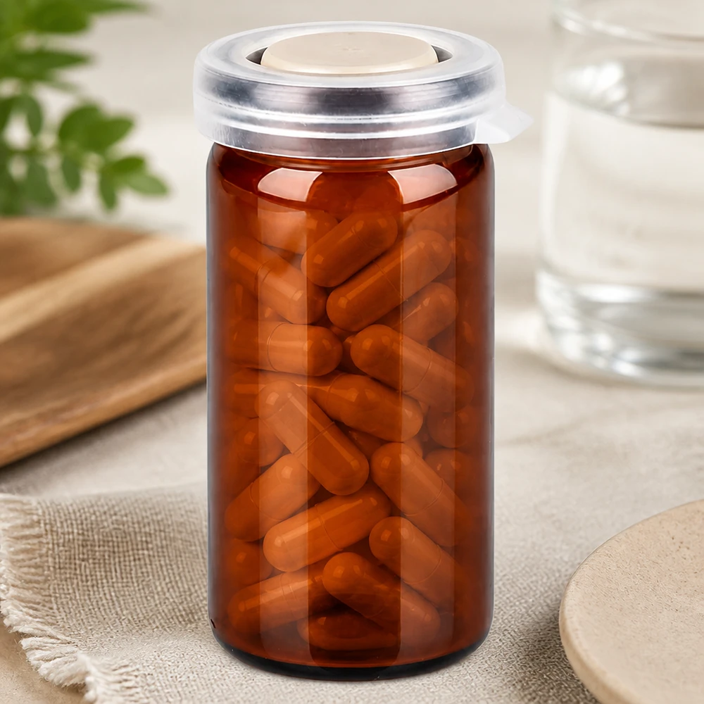 Tablet/roll rim-purkki 10ml ruskea, jossa on napsautettava kansi. 10 ml:n apteekkilasi, ruskeaa lasia, napsautuskannella, täytetty ruskeilla kapseleilla