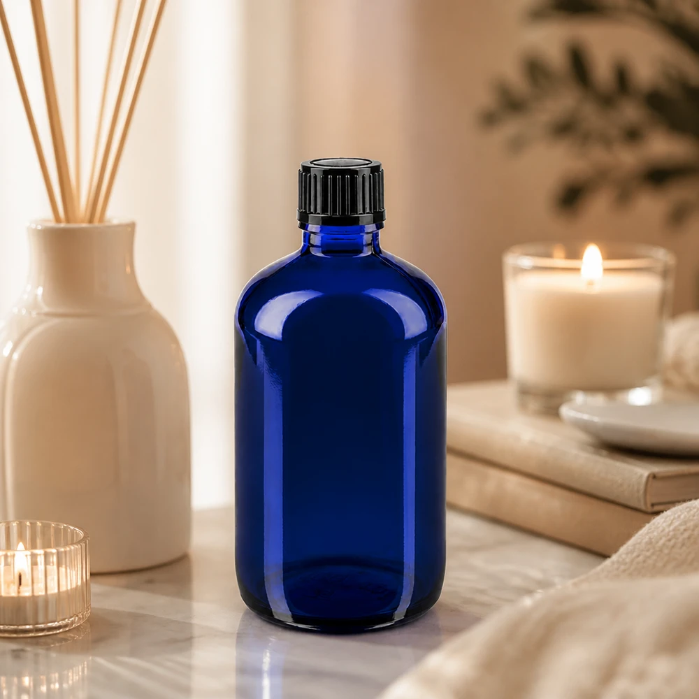 Apteekkipullo sininen 100ml ruuvikorkki musta standardi Koboltinsininen 100 ml:n apteekkipullo, jossa on musta tippakorkki, marmorialustalla