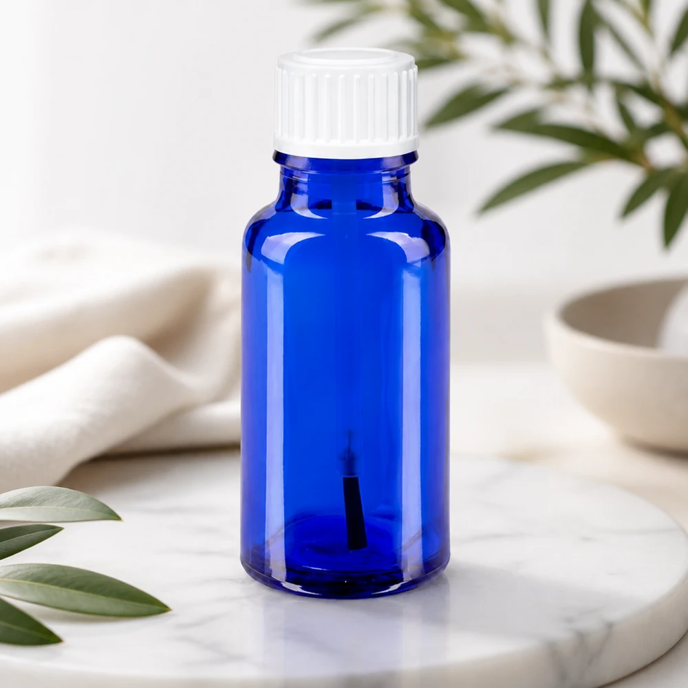 Apteekkipullo sininen 20ml ruuvikorkki valkoinen sivellinlaite Sininen 20 ml:n sivellinpullo apteekkilasista, jossa on valkoinen lapsiturvallinen korkki