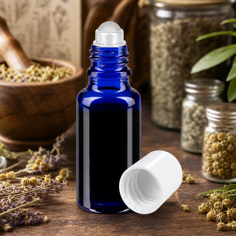Apteekkipullo sininen 20ml roll-on korkki valkoinen 20 ml:n sininen apteekkilasinen roll-on-pullo, jossa on valkoinen kierrekorkki, laventelin ja yrttien välissä