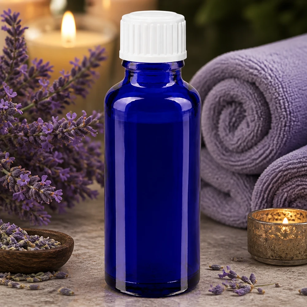 30 ml:n sininen lasipullo, jossa on valkoinen 3 mm:n tiputuskärki, ympäröity laventelikukilla ja spa-tarvikkeilla