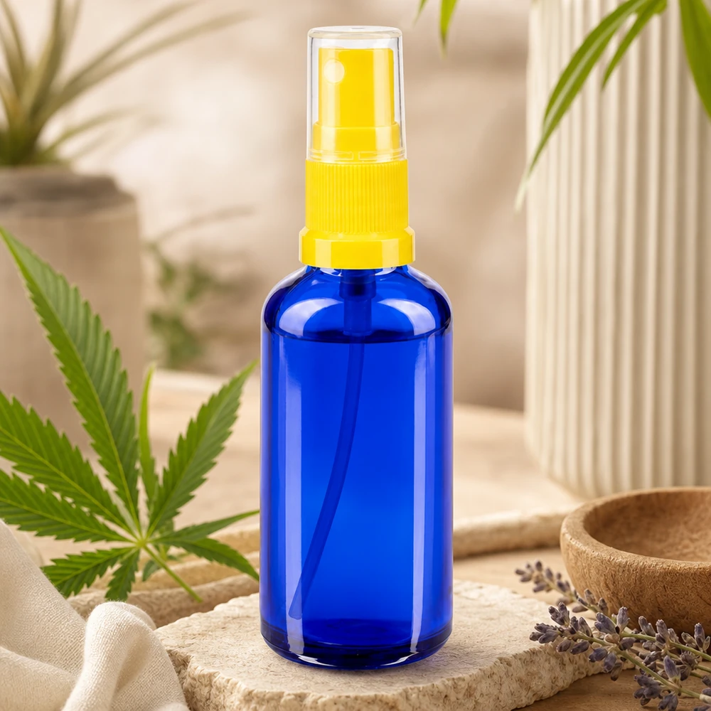 Sininen 50 ml:n STD-suihkepullo apteekkilasista, jossa on keltainen sumutin ja kannabiksen lehti