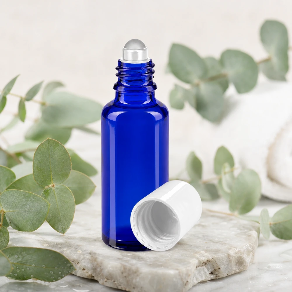 Apteekkipullo sininen 30ml roll-on korkki valkoinen 30 ml:n roll-on-pullo koboltinsinisestä apteekkilasista, valkoisella korkilla ja eukalyptusoksilla