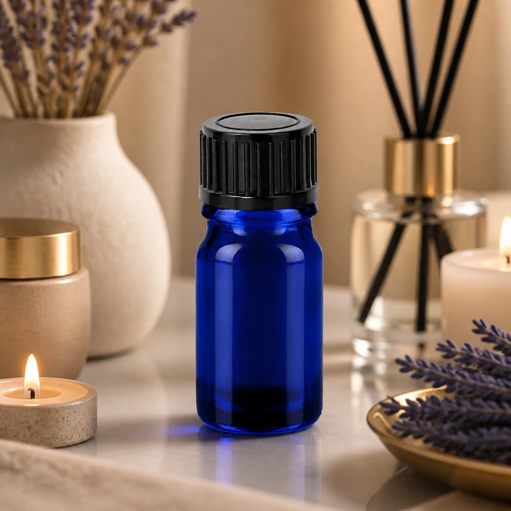 Pieni 5ml aromaterapiapullo sinisestä lasista, jossa on tiivis musta korkki.