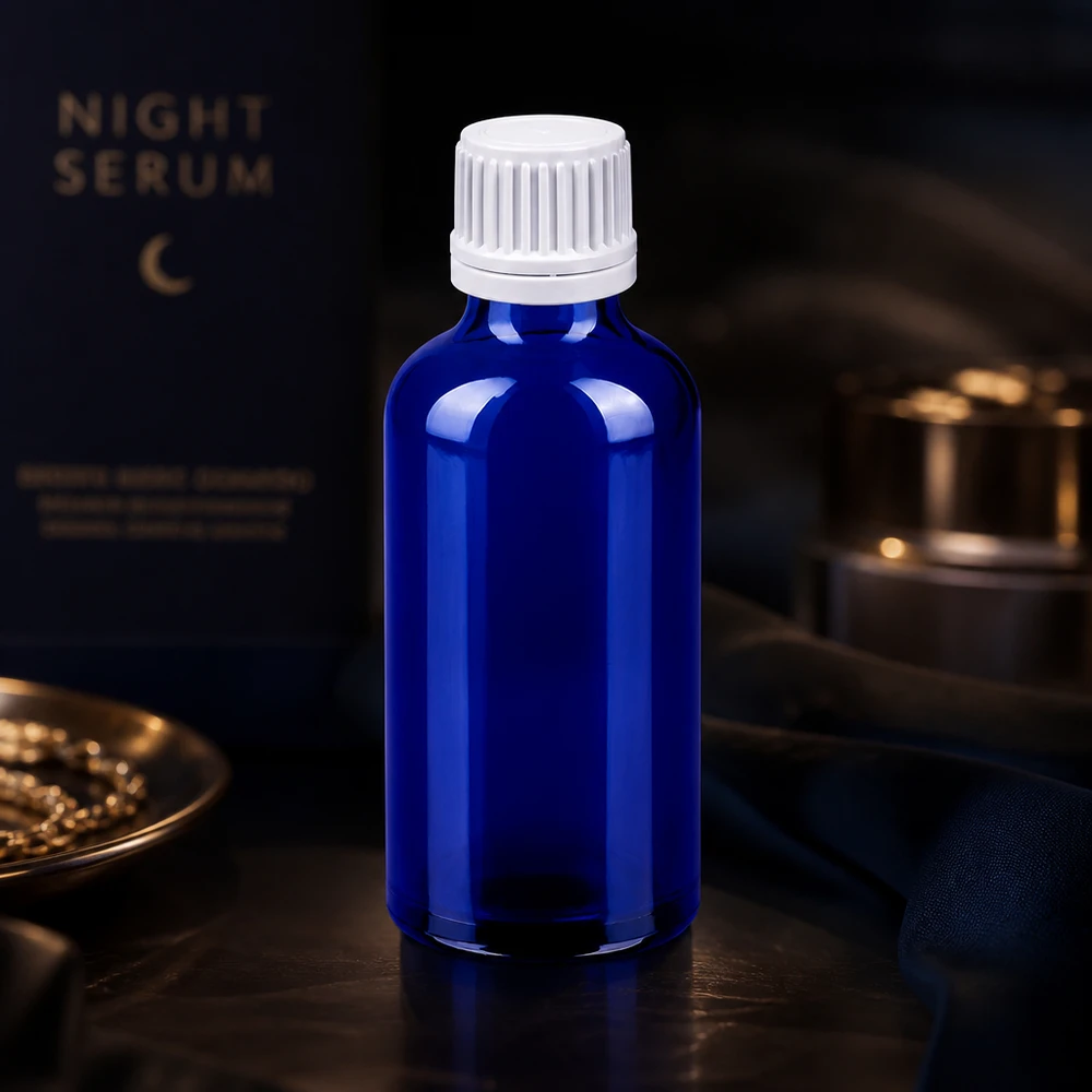 Tyylikäs sininen lasipullo 50ml, jossa on valkoinen tippakorkki nesteiden tarkkaa annostelua varten.