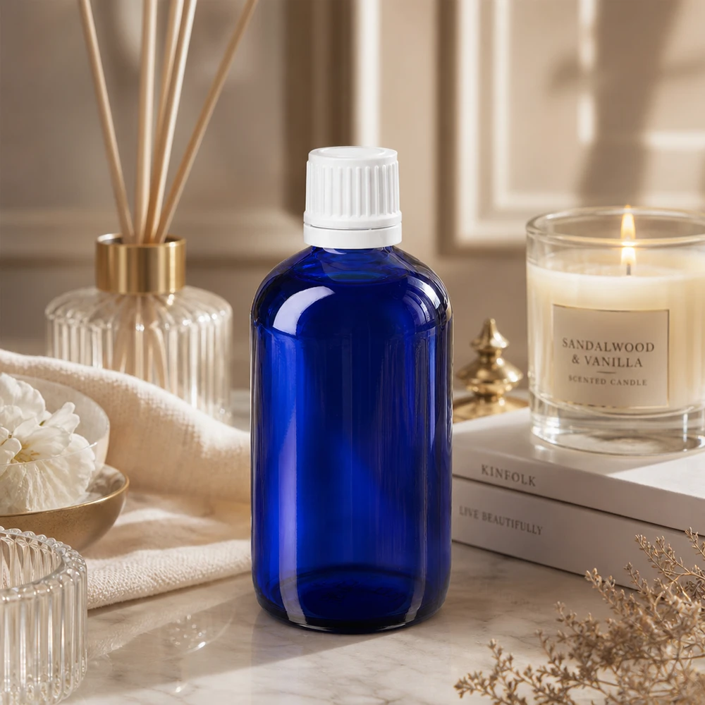 Apteekkipullo sininen 100ml ruuvikorkki valkoinen peukaloinninesto sulkeminen Sininen 100 ml:n lasinen apteekkipullo, jossa on lapsiturvallinen valkoinen korkki, marmorilla sandelipuu-kynttilän vieressä
