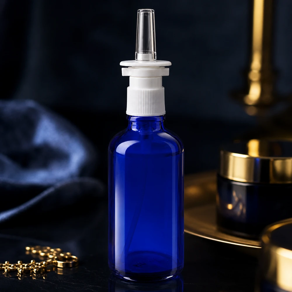 50 ml:n nenäsumutepullo sinisestä apteekkilasista, jossa on valkoinen korkki ja kirkas nenäsuutin