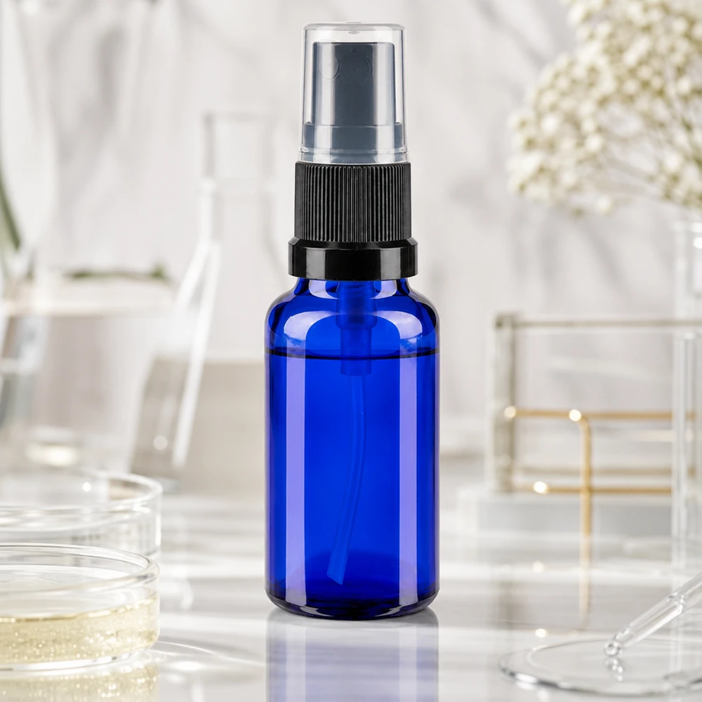 Apteekkipullo sininen 20ml ruiskutuspääte musta Sininen 20 ml:n laboratoriotäyttöpullo, jossa on musta sumutin valkoisella marmoritaustalla