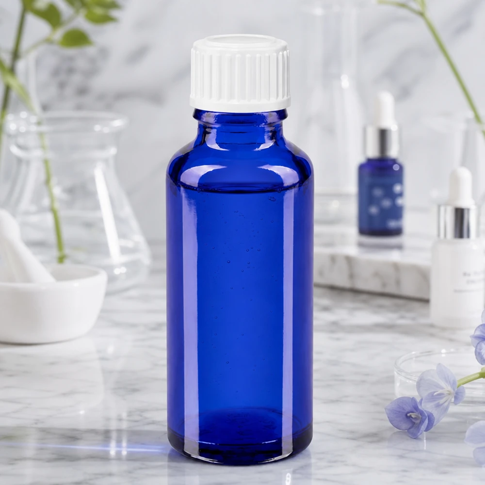 Sylinterimäinen 30 ml:n lääkelasipullo, koboltinsininen, valkoisella kierrekorkilla, marmorikuvioinen