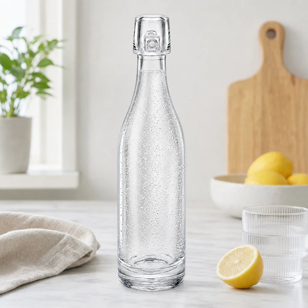 50ml lasipullo ilman kääntökorkkia UNiTWIST 50ml UNiTWIST-lasipullo täynnä kuohuvaa vettä modernissa keittiössä sitruunoiden ja lasien vieressä valkoisella työtasolla.