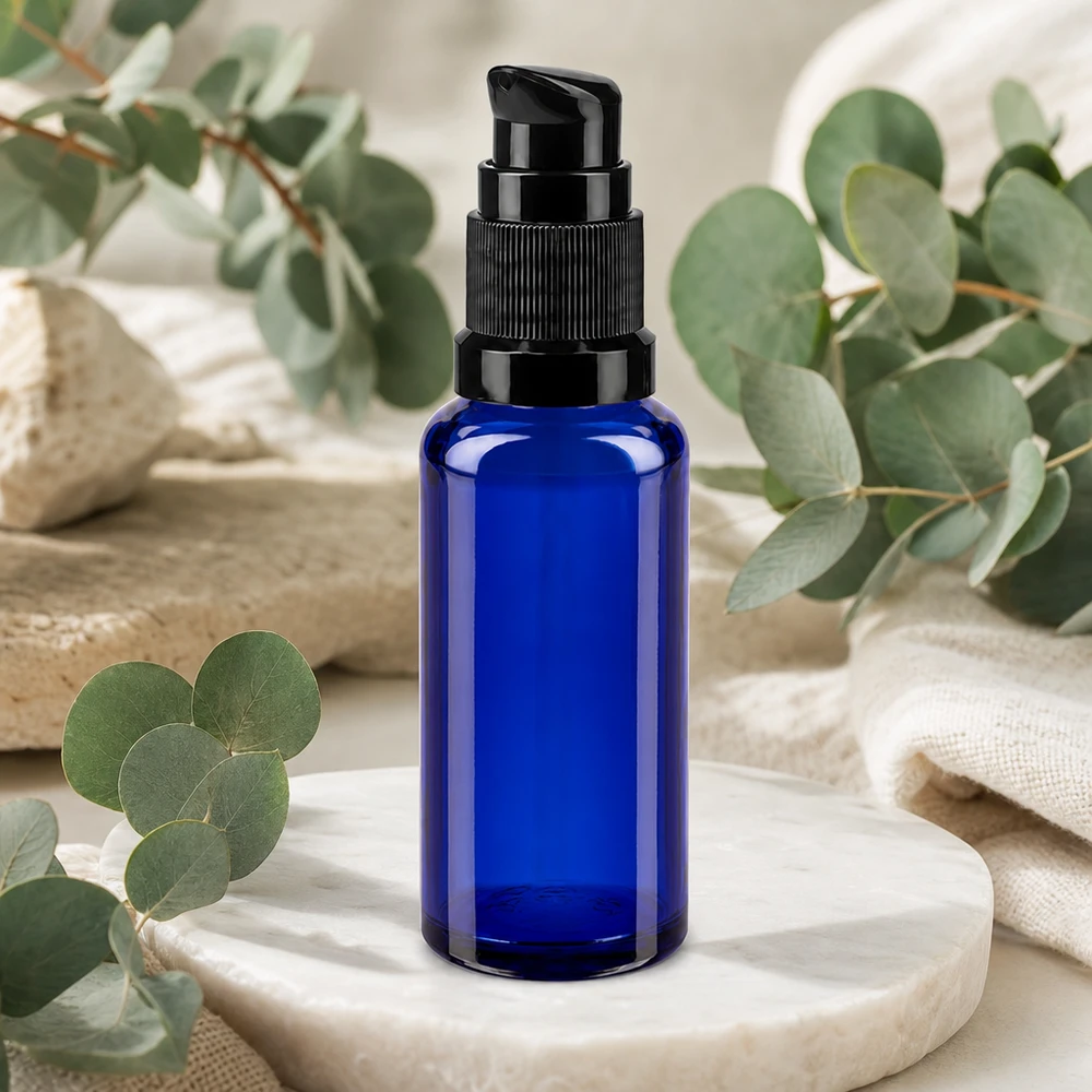 Apteekkipullo sininen 30ml pumppukorkki musta standardi Sininen 30 ml:n pumppupullo apteekkilasista, jossa on musta annostelupää marmorikivellä