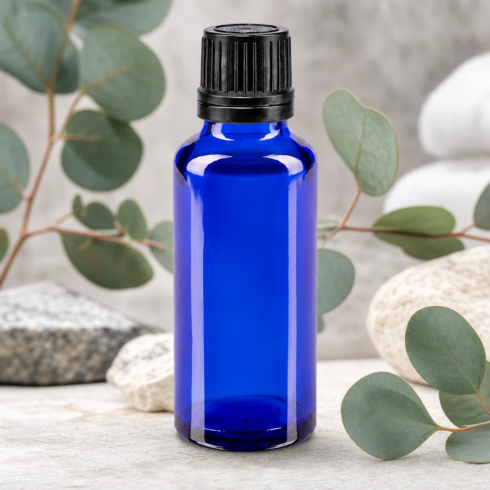 Apteekkipullo sininen 30ml ruuvikorkki musta valurengas sinetöintiturvallinen sulkeminen Pieni sininen lasipullo, 30 ml, jossa on musta alkuperäiskorkki, eukalyptusoksien edessä