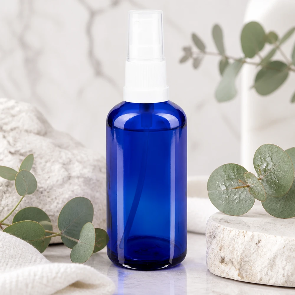 Apteekkipullo sininen 50ml ruiskukorkki valkoinen 50 ml:n sininen lasinen suihkepullo, jossa on valkoinen sumutin, marmorikuvio ja eukalyptuksen tuoksu